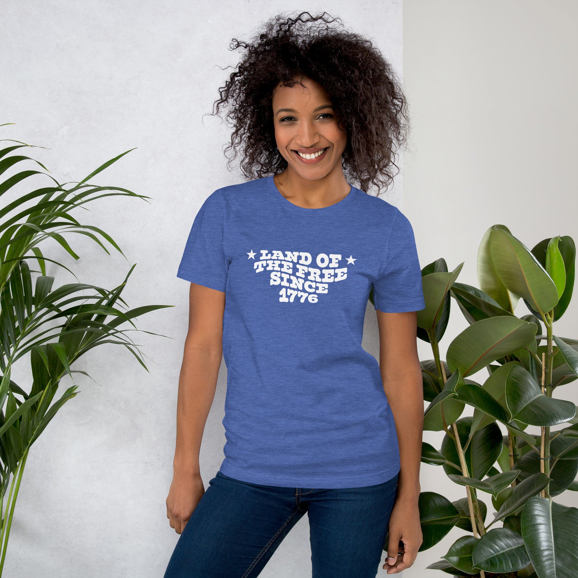 Woman wearing a blue t-shirt with white text that says “LAND OF THE FREE SINCE 1776.”
