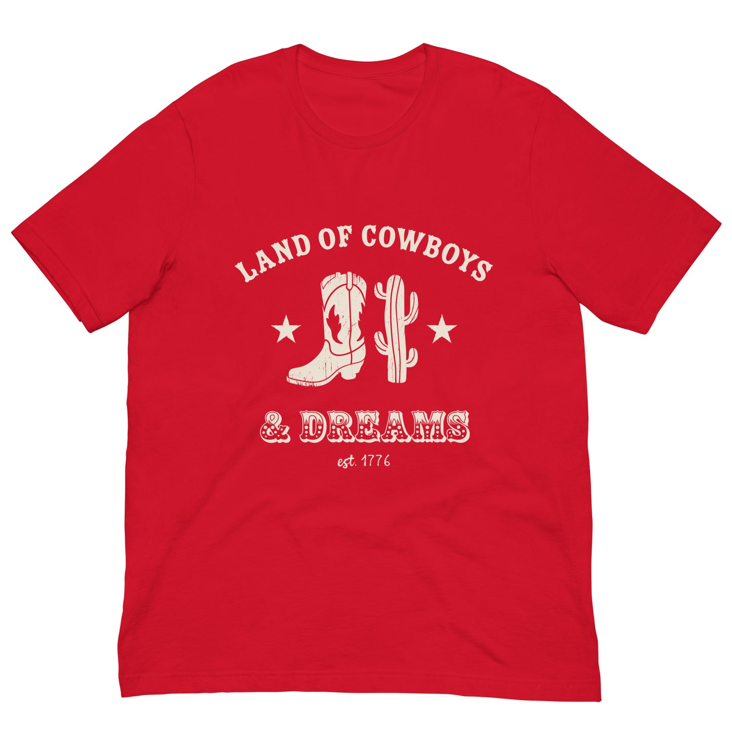 Red t-shirt with a white graphic featuring a cowboy boot, cactus, and text that says “Land of the Cowboys and Dreams est. 1776.”