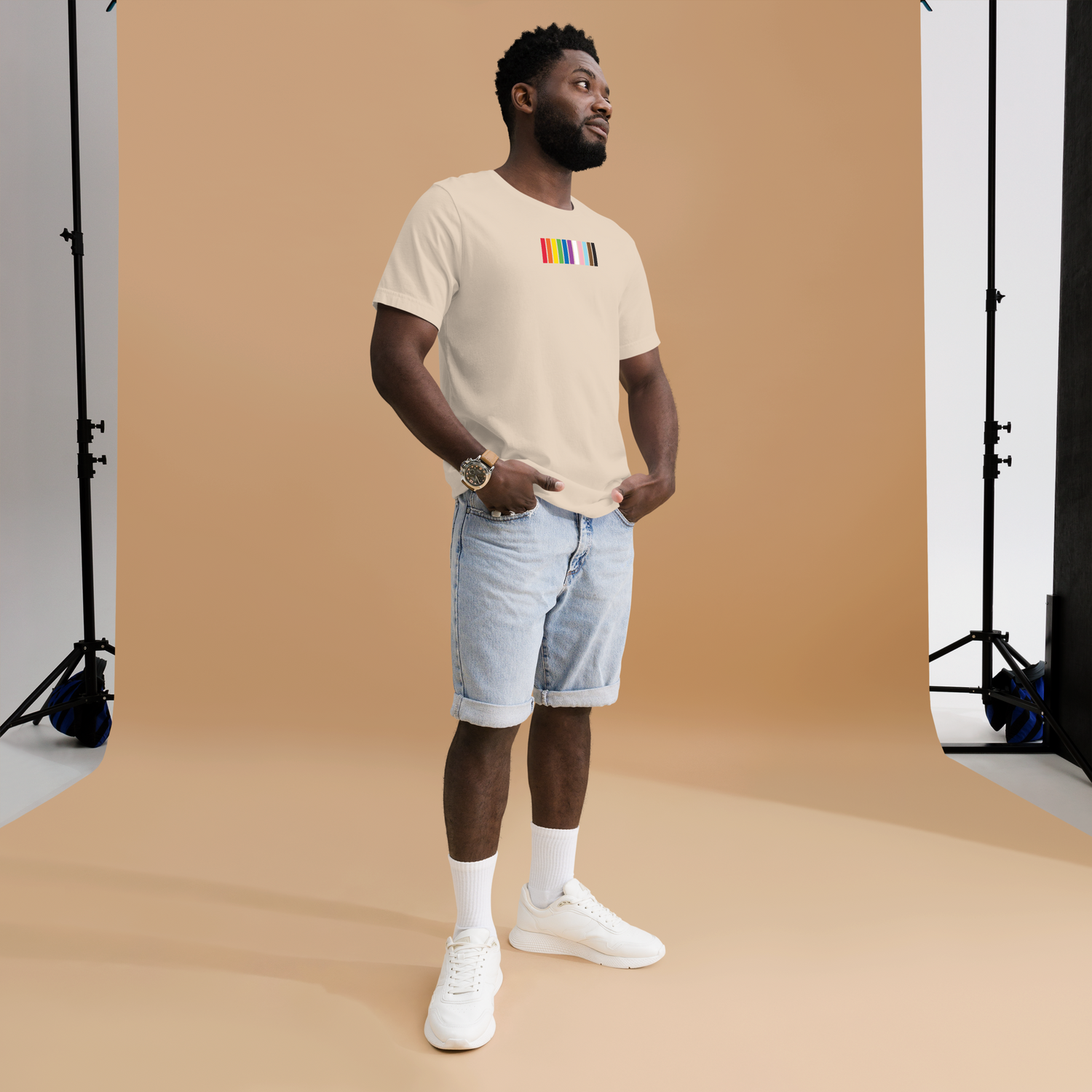 Man wearing a rainbow-striped Pride t-shirt from the LGBTQ+ collection, standing and posing for the photo.